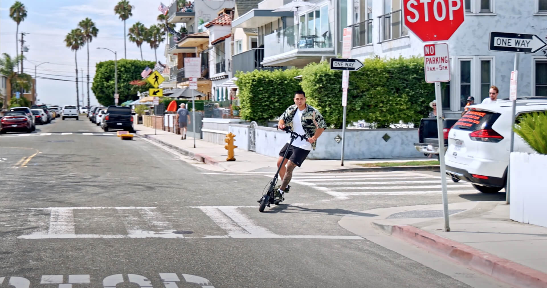 Man crossing street on electric scooter